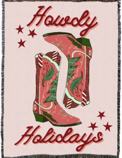 Woven throw blanket featuring two red cowboy boots decorated with holly and candy canes, with the text Howdy Holidays and red stars.