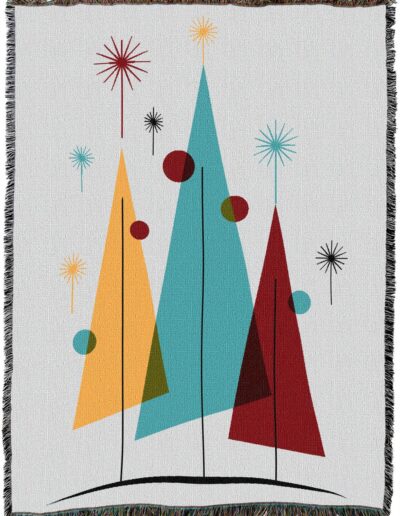 Woven throw blanket featuring a mid-century modern graphic of three triangular trees in yellow, teal, and red, accented with starbursts and circular shapes.