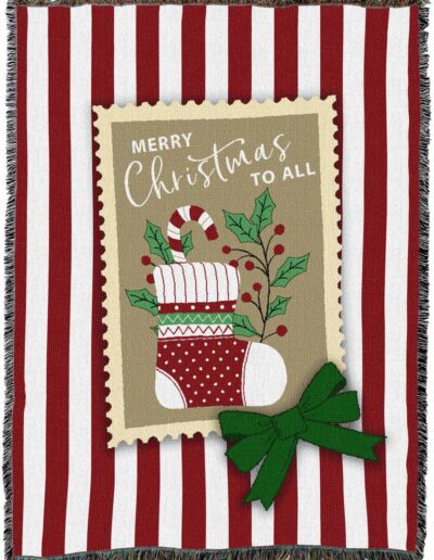 Woven blanket with red and white vertical stripes featuring a central graphic of a Christmas stocking and a candy cane, with the text Merry Christmas to All.