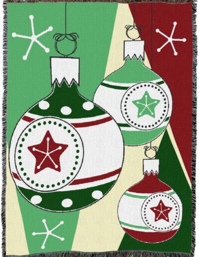 Woven throw blanket featuring a Christmas ornament pattern of red and green stars and stripes against a background of geometric triangles and white stars.