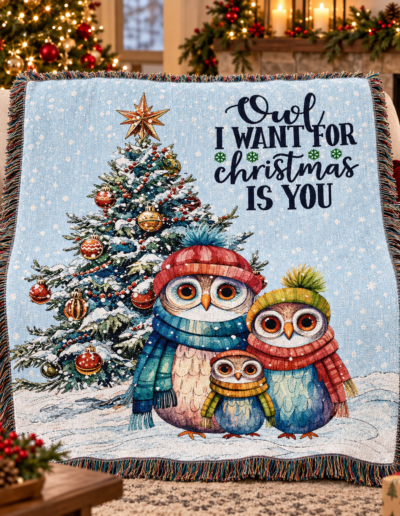 Woven throw blanket featuring three owls in winter hats and scarves standing before a Christmas tree, with the text Owl I want for Christmas is you.