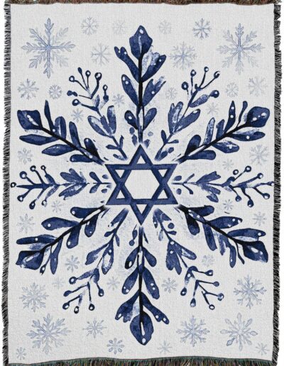Woven throw blanket featuring a blue Star of David surrounded by a floral snowflake pattern and smaller snowflakes on a white background.