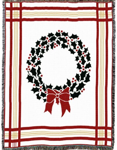 Woven throw blanket featuring a central holly wreath with a red bow, framed by red and gold striped borders.