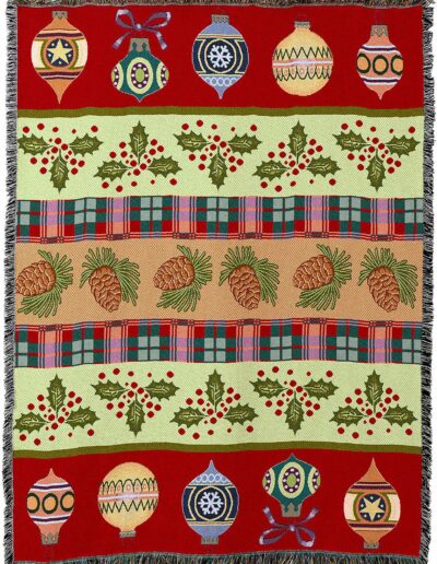 A woven throw blanket featuring horizontal rows of Christmas ornaments, holly berries, and pinecones on a red, green, and tan plaid-patterned background.